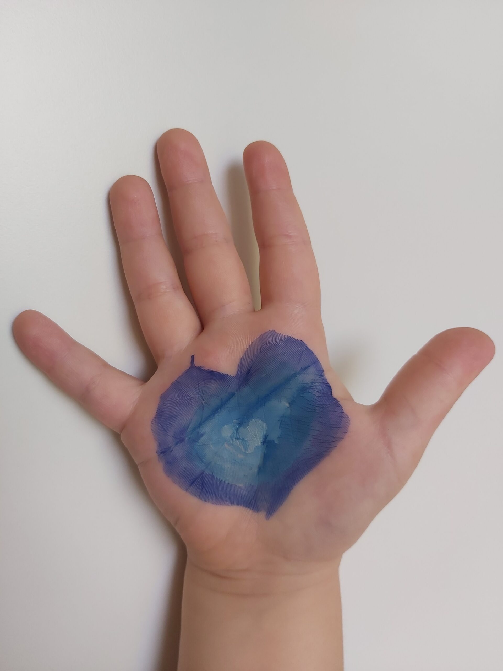 Mano con il disegno di un cuore blu