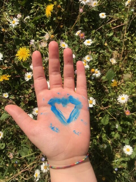 Mano con il disegno di un cuore blu